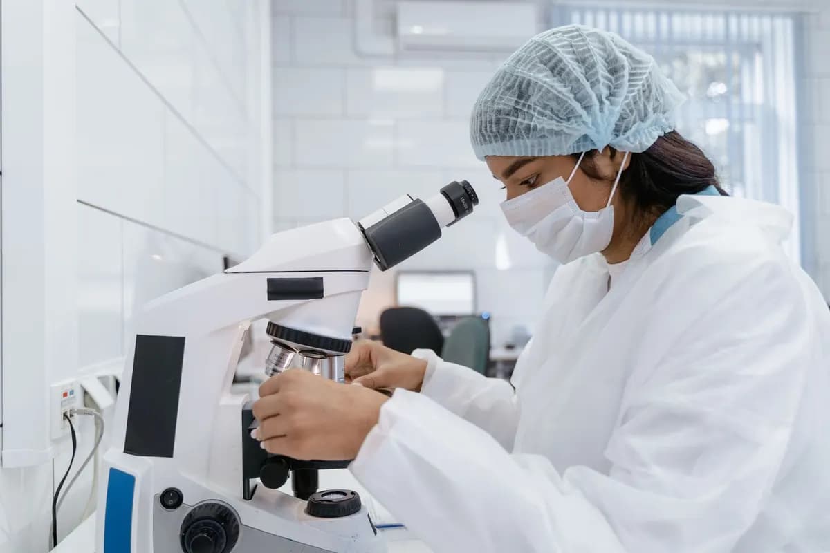 Lab technician analysing samples under a microscope